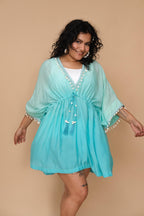 Woman wearing a turquoise cover-up with white trim
