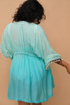Plus size woman wearing a light blue kaftan with white embellishments 