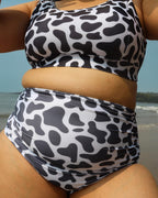 Woman wearing a cow print swimsuit 
