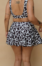 Woman wearing a black and white cow print swim set