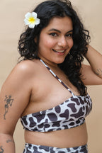Woman wearing a cow print  bikini top 