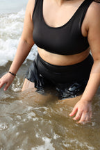 Plus size woman wearing a black swimsuit