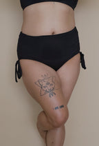 Asian woman wearing black high-waisted bikini bottoms 