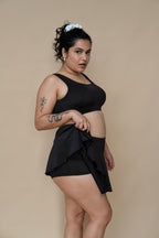 Woman wearing a black bikini top and skirt 