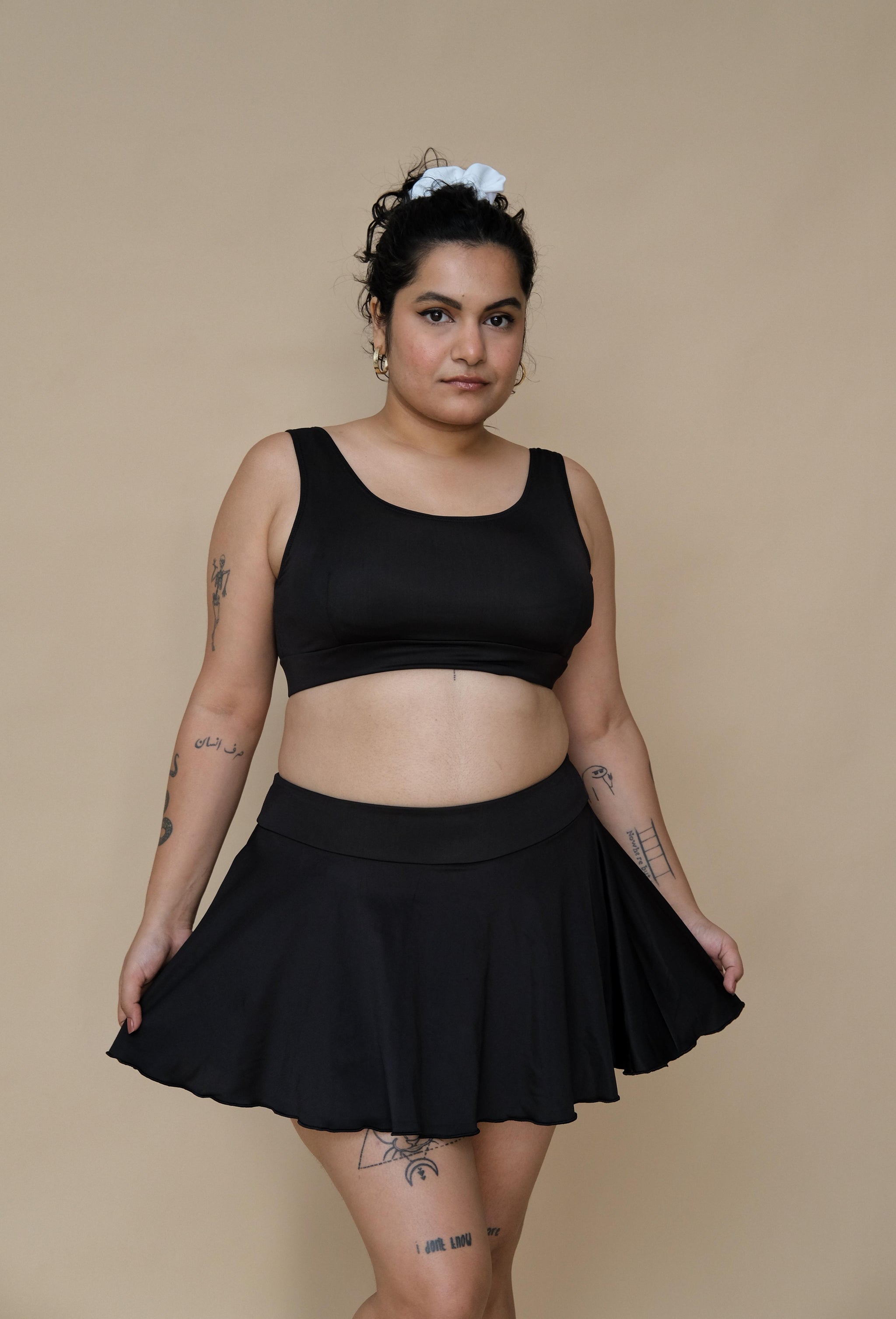 Woman wearing a black bikini top and skirt 