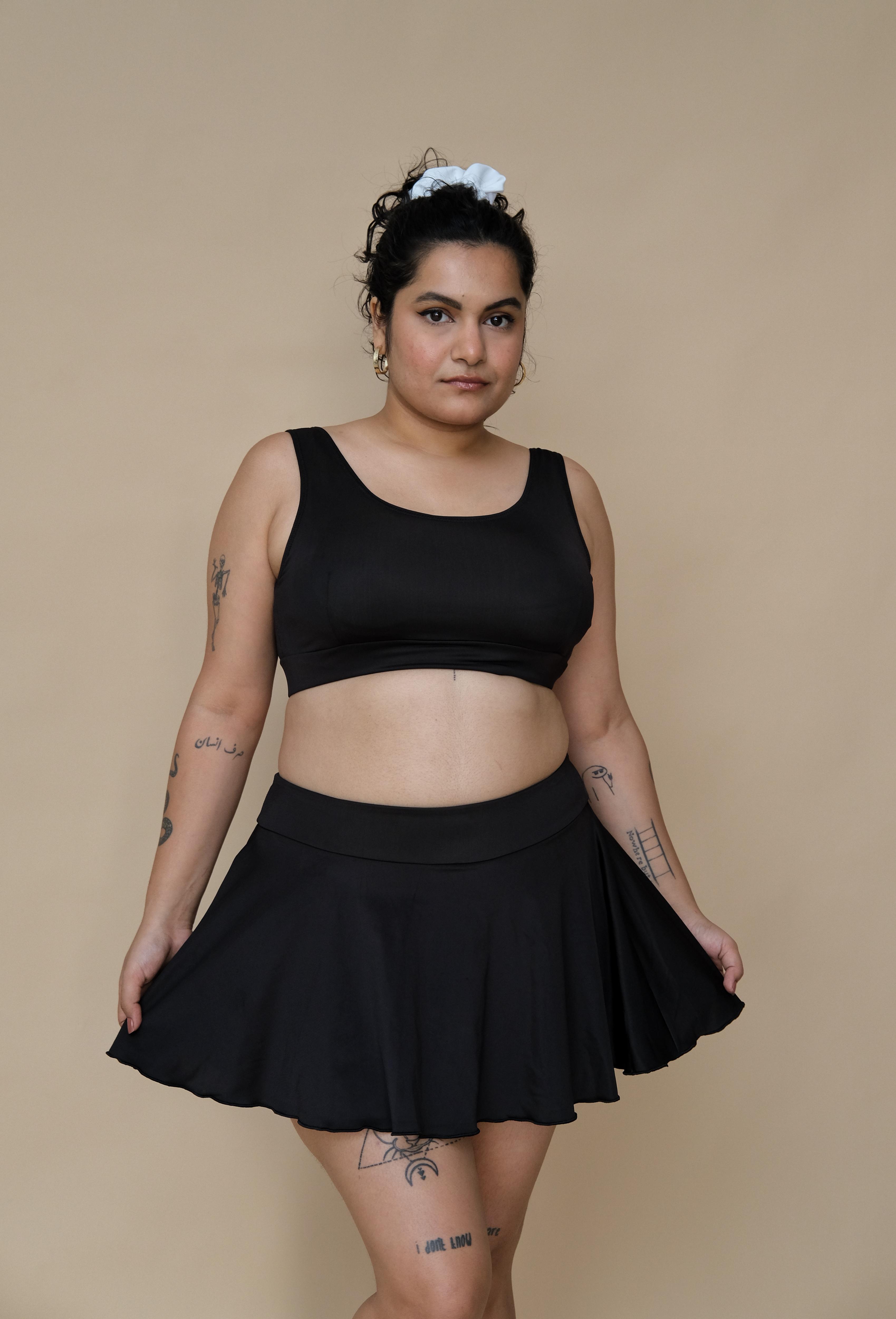 Woman wearing a black bikini top and skirt 