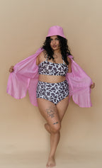 Woman wearing a cow print bikini and pink cover-up 
