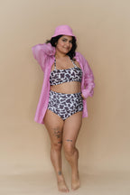 Woman wearing a cow print bikini and pink shirt