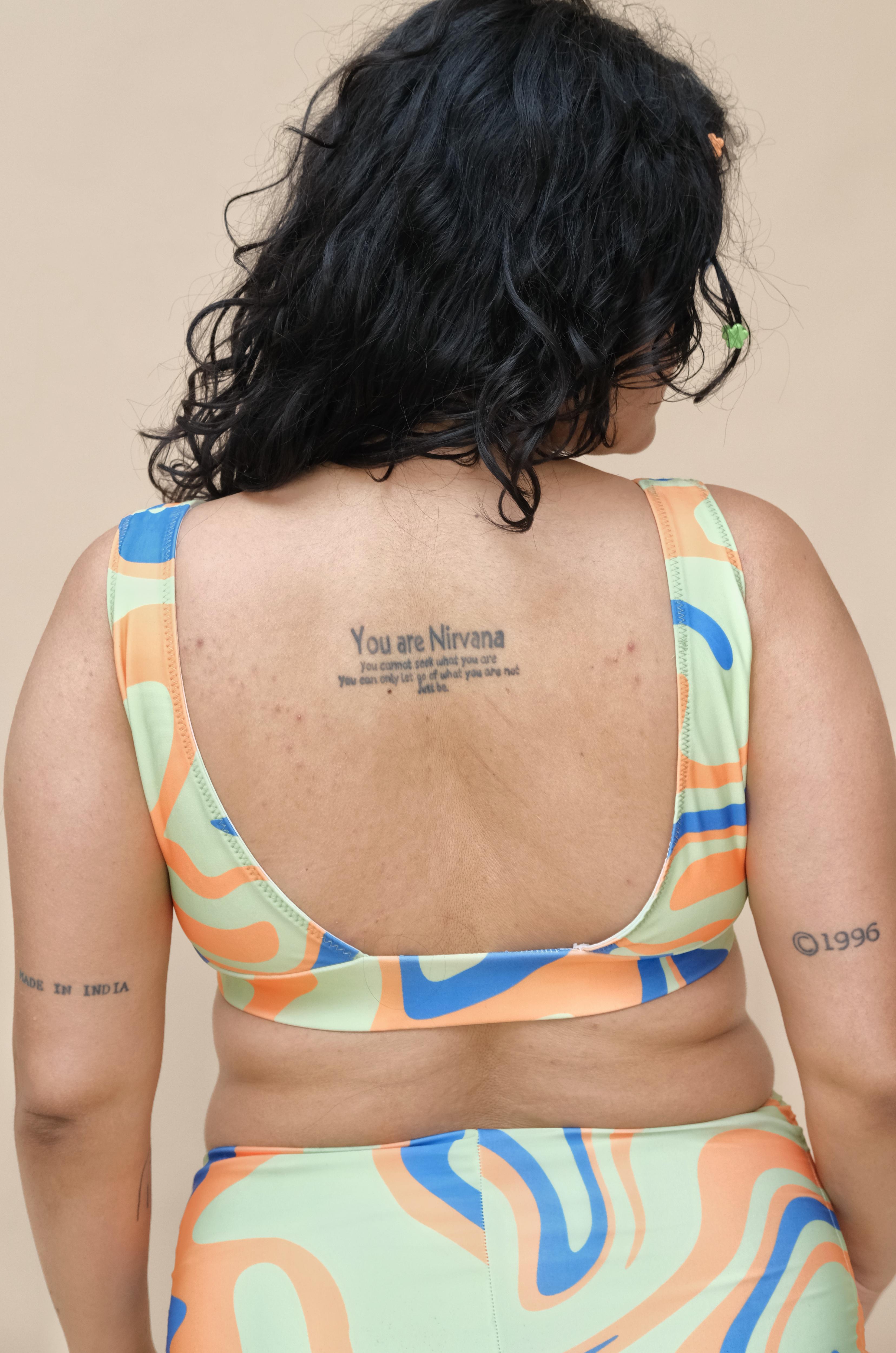 Plus size woman wearing a colorful swimsuit top