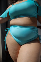 Curvy woman wearing a turquoise bikini set 