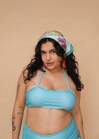 Woman wearing a blue bikini and colorful headscarf 