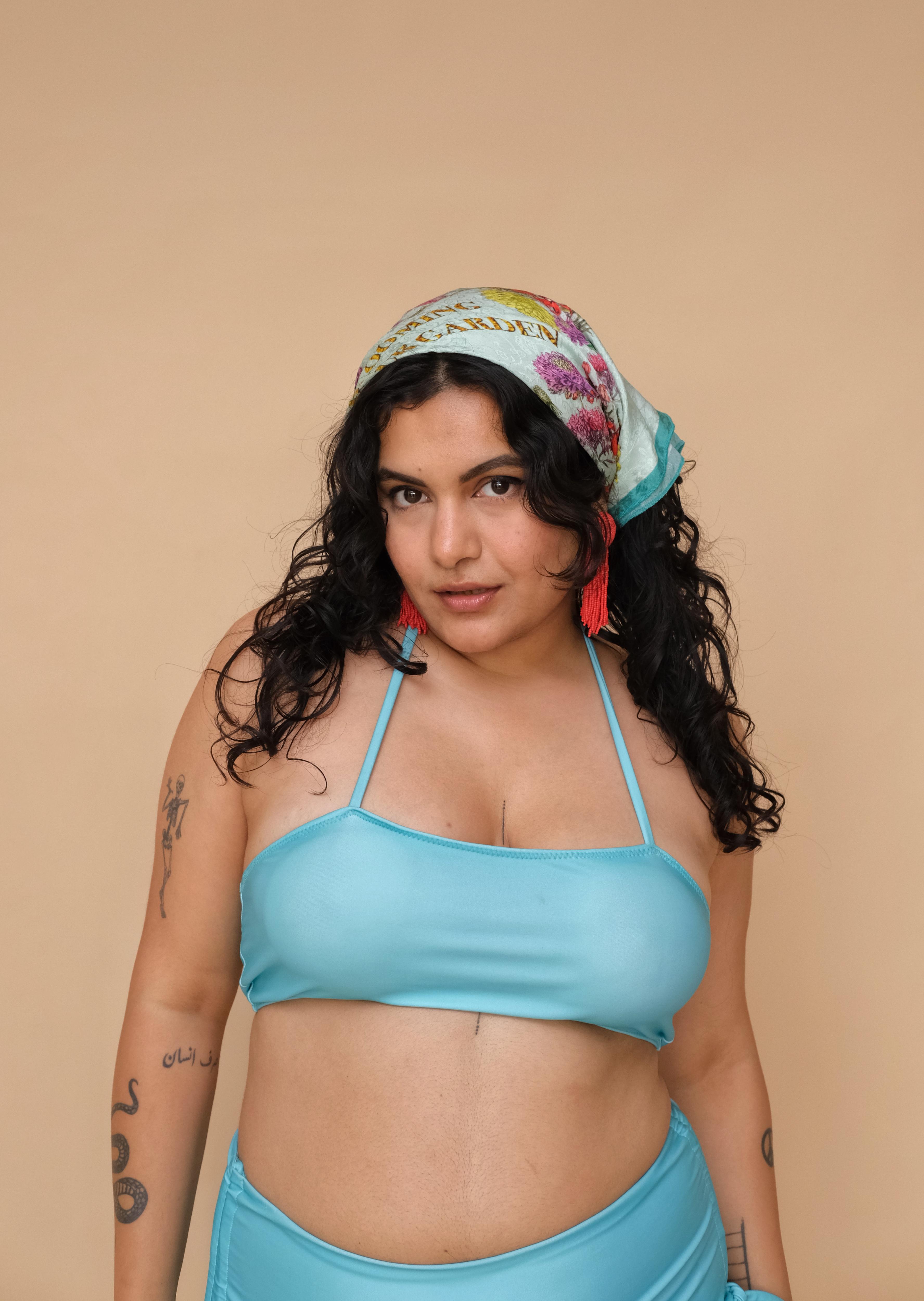 Woman wearing a blue bikini and colorful headscarf 