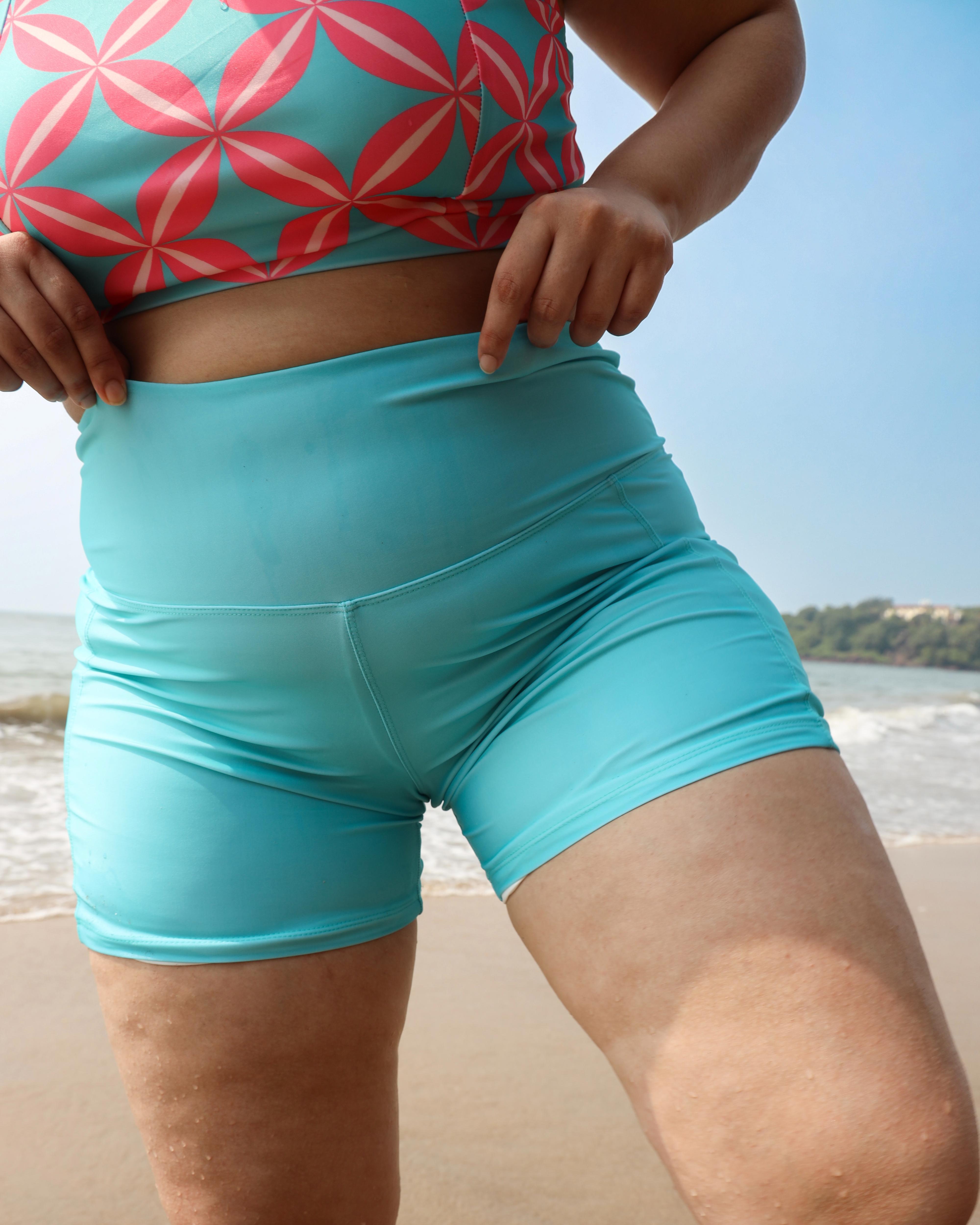 Plus size wearing a colorful top and blue shorts 