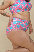 Woman wearing a pink and blue patterned two-piece swimsuit 
