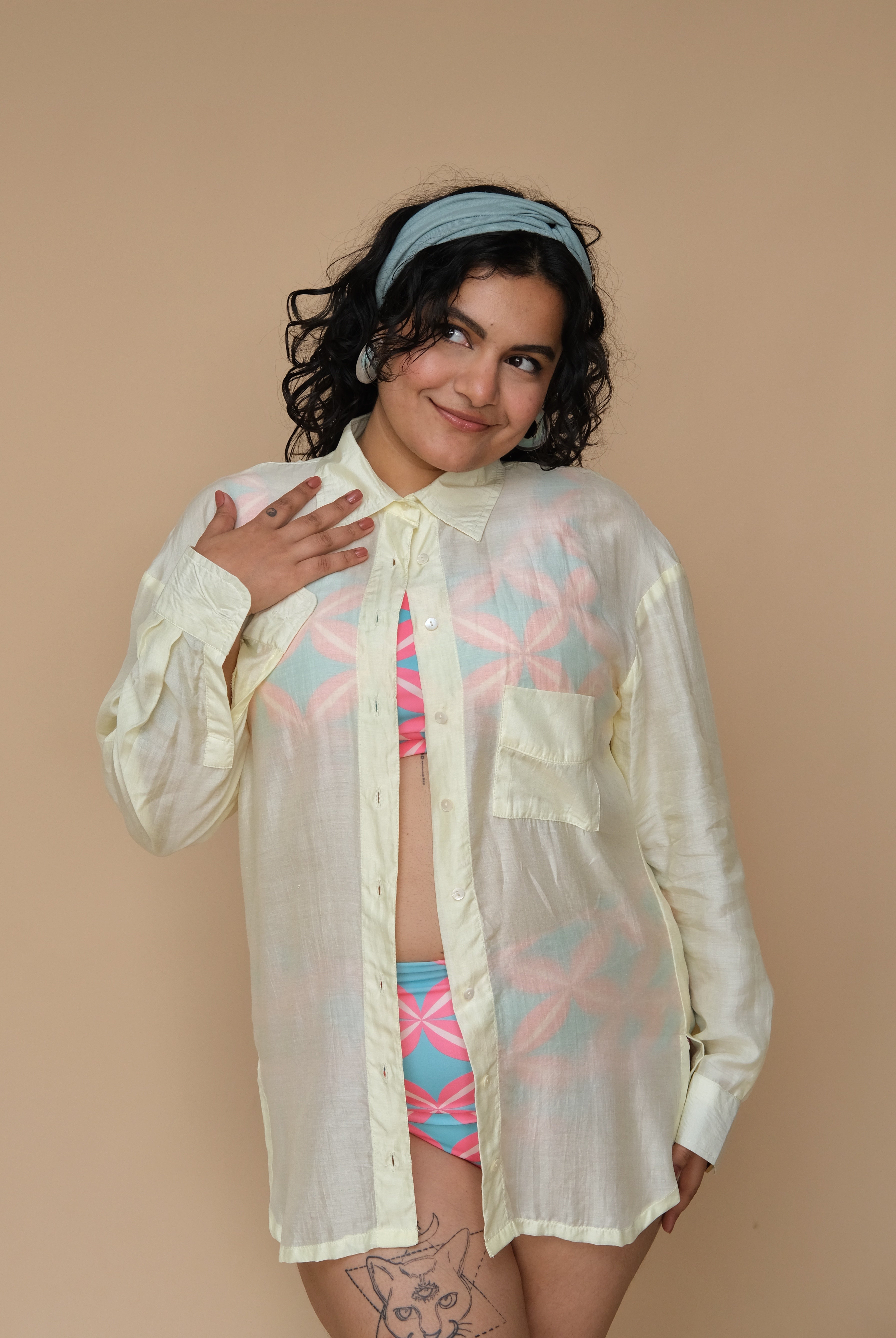 Woman wearing a sheer lime shirt over a colorful bikini set