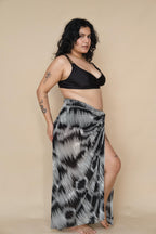 Woman wearing a black bikini top and patterned sarong 