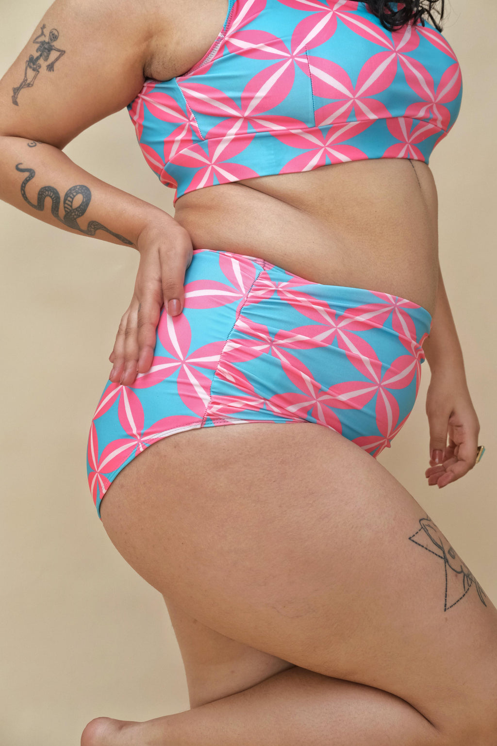 Curvy woman wearing a pink and blue patterned two-piece swimsuit 
