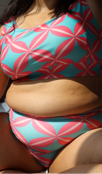 curvy plus size woman wearing a colorful bikini with pink and blue pattern