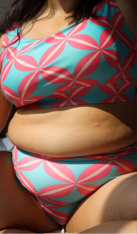curvy plus size woman wearing a colorful bikini with pink and blue pattern