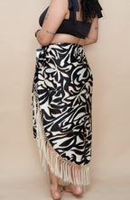 Woman wearing a black and white patterned skirt with fringes 