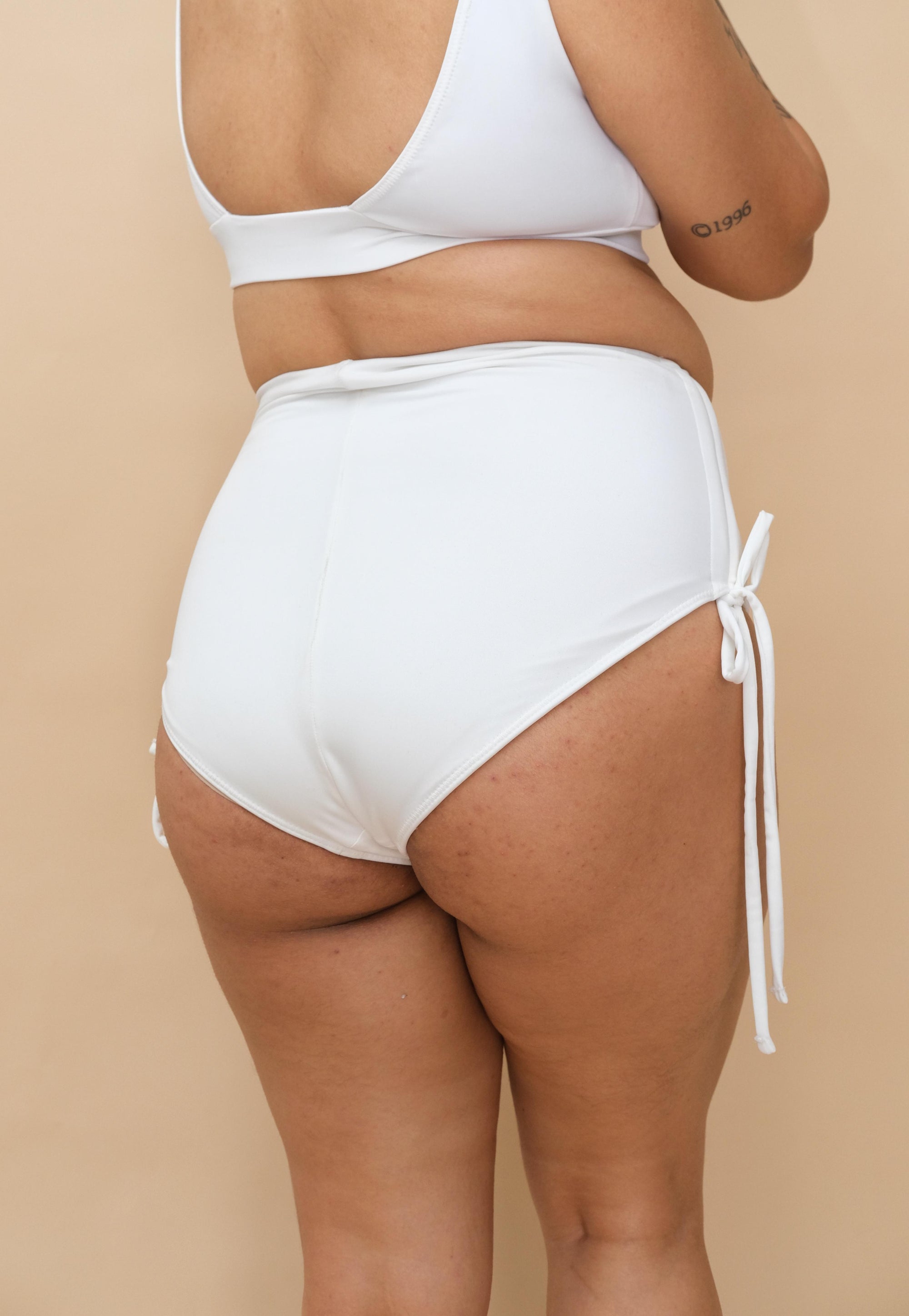 Woman wearing white bikini bottom