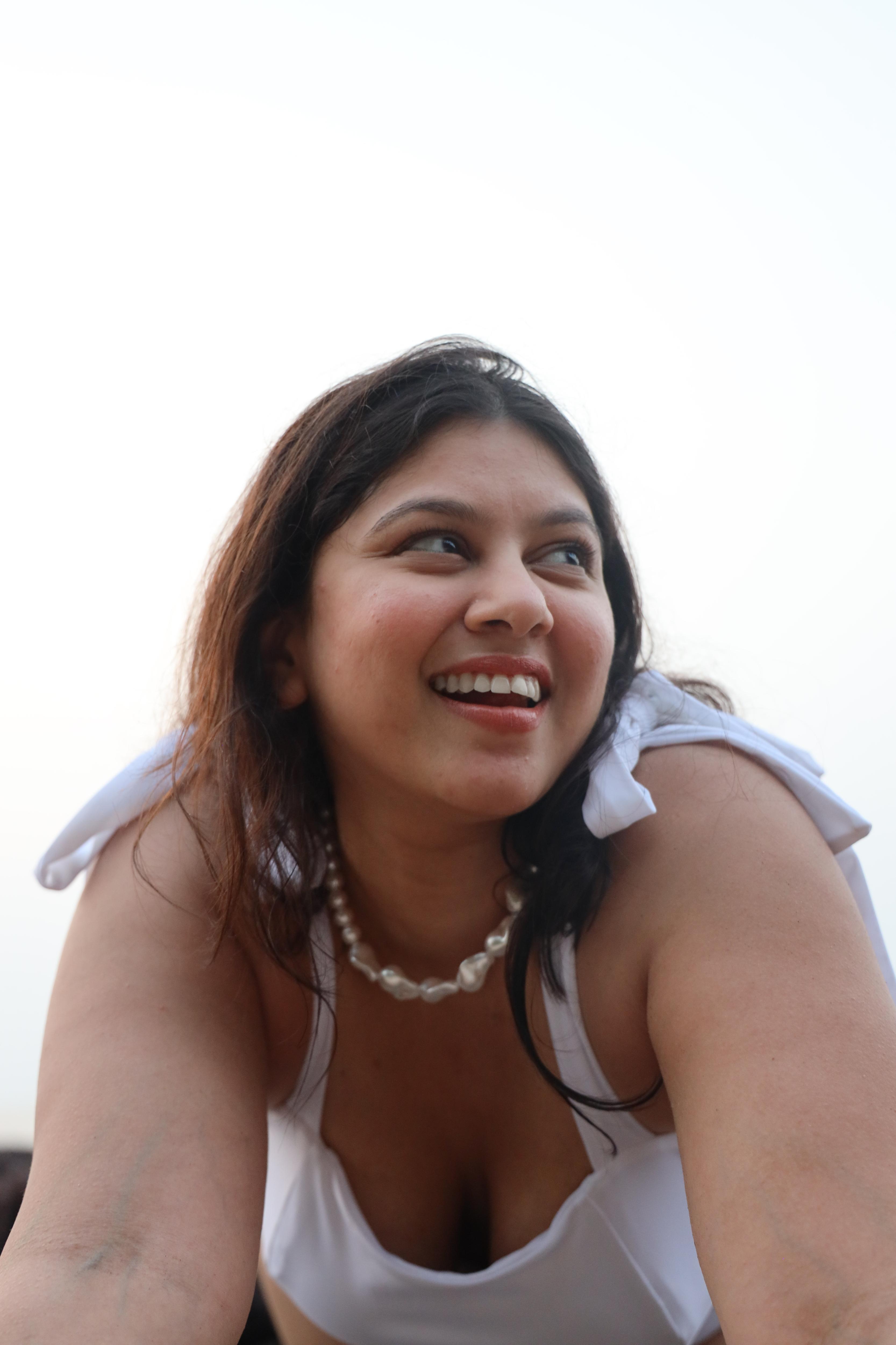 Woman wearing a white top and pearl necklace 