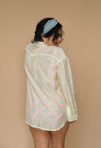 Woman wearing a sheer lime shirt with geometric patterns 