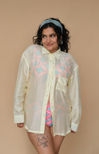 Woman wearing a sheer lime shirt with colorful patterns over a swimsuit 