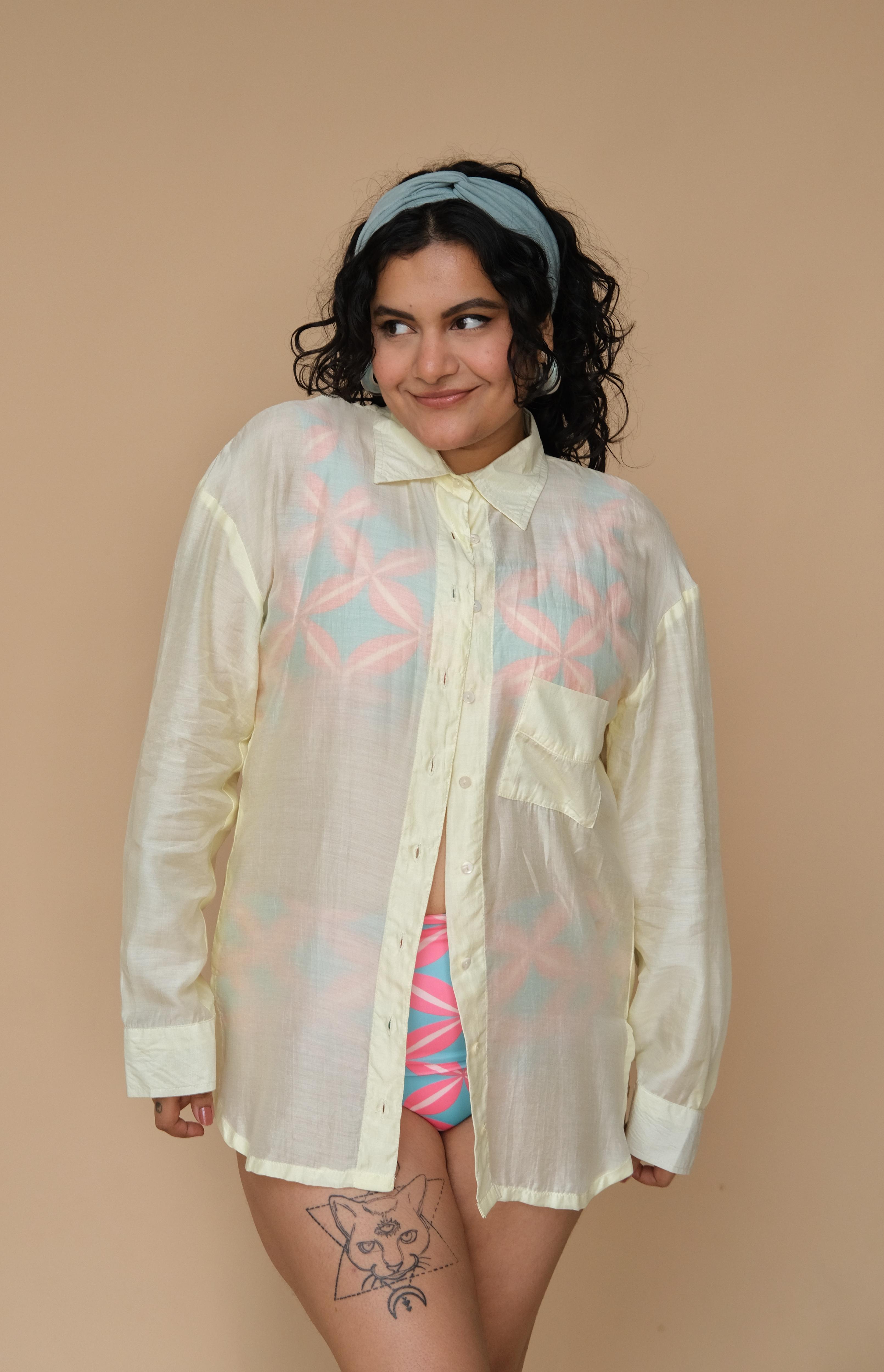 Woman wearing a sheer lime shirt with colorful patterns over a swimsuit 