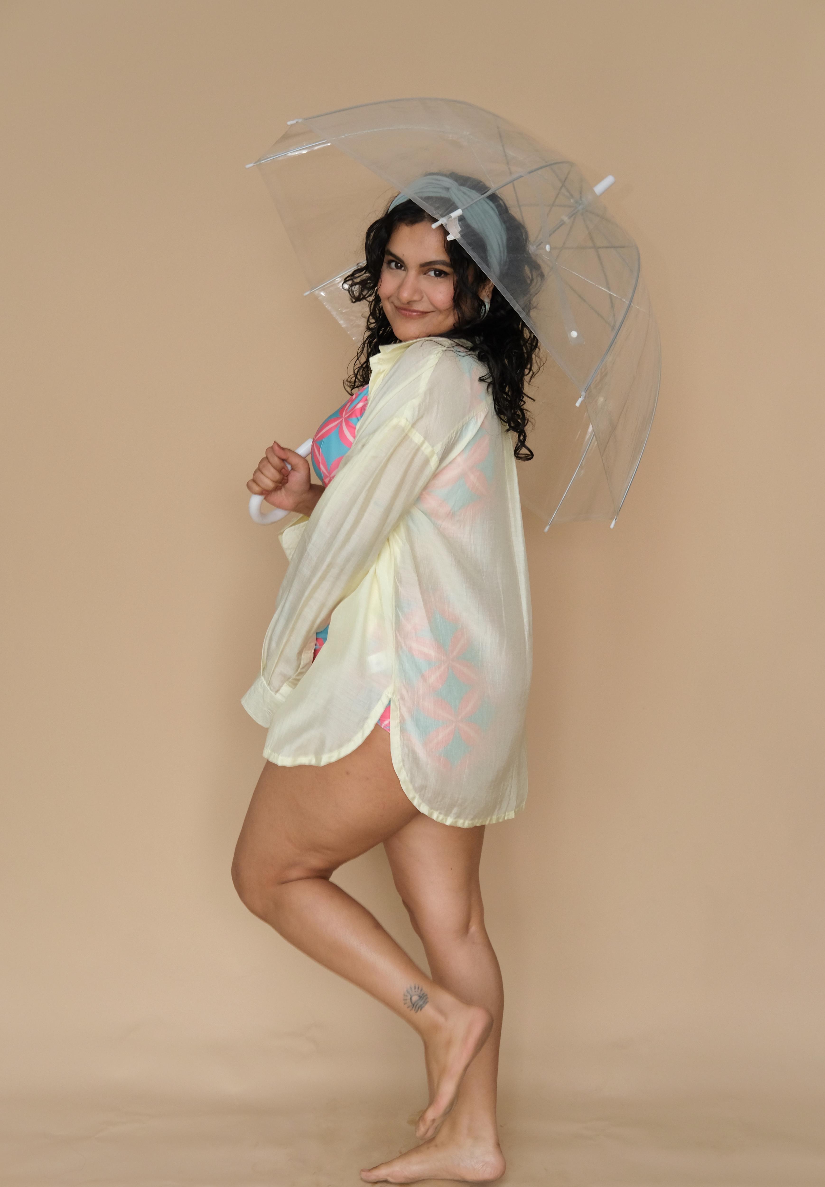 Woman holding a clear umbrella wearing lime shirt cover-up
